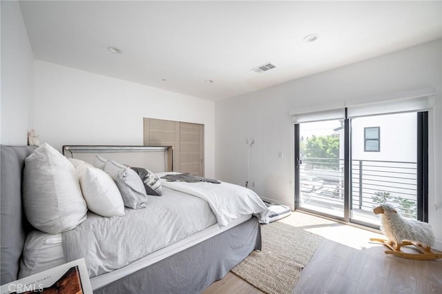 bedroom featuring access to exterior and wood finished floors
