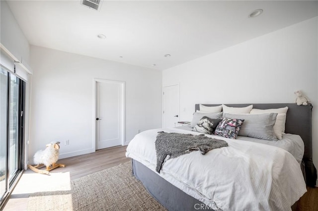 bedroom featuring wood finished floors, baseboards, and recessed lighting