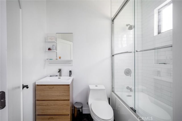 bathroom featuring toilet, vanity, and combined bath / shower with glass door