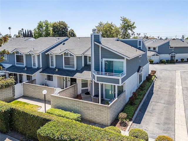 173 N Magnolia Ave Unit A, Anaheim, CA 92801 - view of front of house with a fenced front yard, a chimney, a residential view, a balcony, and a shingled roof