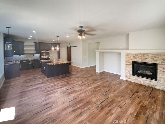 8424 Monique Ct, Riverside, CA 92508 - living area featuring dark wood finished floors, baseboards, a stone fireplace, a ceiling fan, and recessed lighting