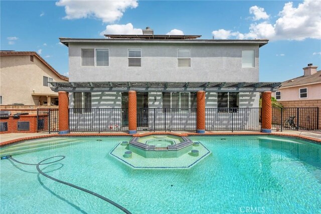 870 E Bermuda Dunes Ct, Ontario, CA 91761 - view of swimming pool with a pergola, a pool with connected hot tub, exterior kitchen, and a patio area
