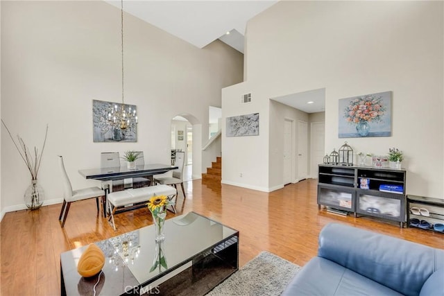 870 E Bermuda Dunes Ct, Ontario, CA 91761 - living area featuring arched walkways, baseboards, wood finished floors, stairs, and a towering ceiling