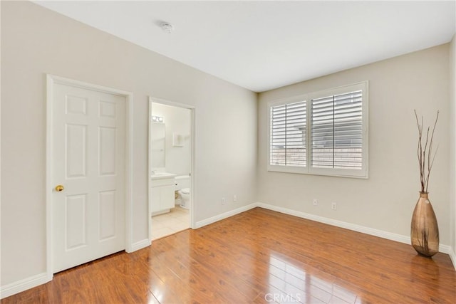 870 E Bermuda Dunes Ct, Ontario, CA 91761 - unfurnished bedroom with hardwood / wood-style flooring, baseboards, and connected bathroom