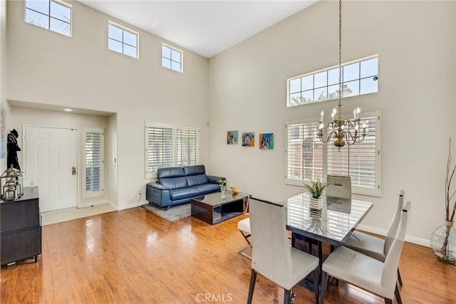 870 E Bermuda Dunes Ct, Ontario, CA 91761 - dining area with a towering ceiling, a chandelier, wood finished floors, and plenty of natural light