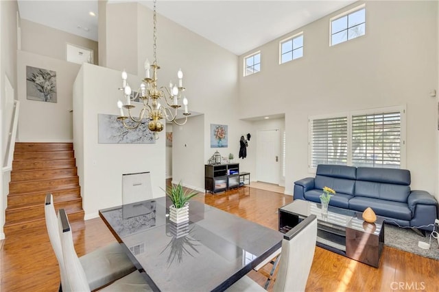 870 E Bermuda Dunes Ct, Ontario, CA 91761 - dining room featuring a high ceiling, wood finished floors, stairs, and a chandelier