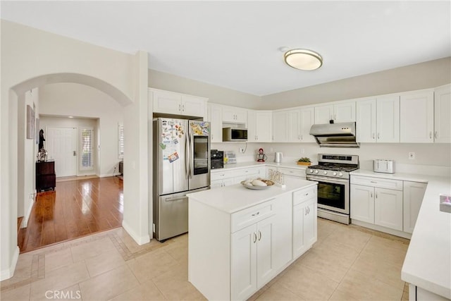 870 E Bermuda Dunes Ct, Ontario, CA 91761 - kitchen featuring stainless steel appliances, arched walkways, under cabinet range hood, light countertops, and a kitchen island