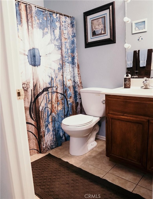 25657 Tamarisk St, Barstow, CA 92311 - bathroom with tile patterned flooring, toilet, vanity, and a shower with shower curtain