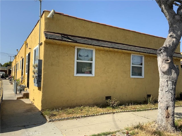 view of side of home with stucco siding and entry steps
