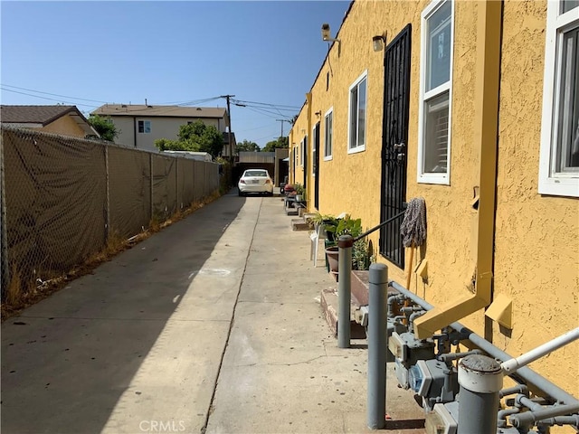 view of home's exterior with stucco siding and fence