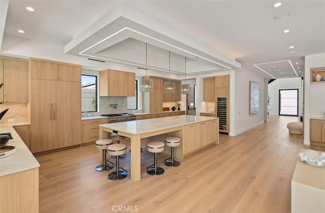5772 Sierra Casa Rd, Irvine, CA 92603 - kitchen featuring modern cabinets, a breakfast bar, light brown cabinetry, light wood-style flooring, and recessed lighting