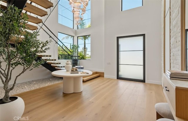 5772 Sierra Casa Rd, Irvine, CA 92603 - dining area with stairway, light wood-style flooring, a towering ceiling, and baseboards
