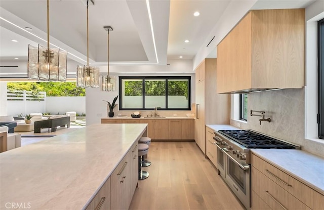 5772 Sierra Casa Rd, Irvine, CA 92603 - kitchen featuring modern cabinets, high end stainless steel range oven, decorative backsplash, light wood-type flooring, and a sink