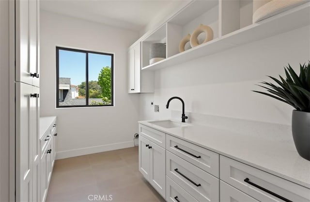 5772 Sierra Casa Rd, Irvine, CA 92603 - kitchen featuring a sink, baseboards, open shelves, and white cabinetry
