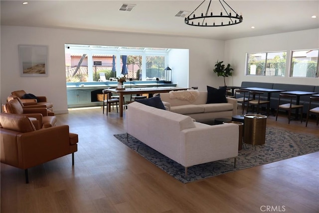 living room with a chandelier, wood finished floors, plenty of natural light, and recessed lighting