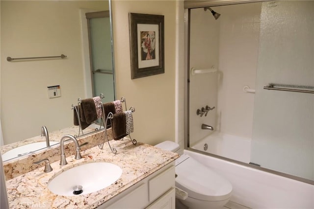 bathroom featuring toilet, vanity, and enclosed tub / shower combo