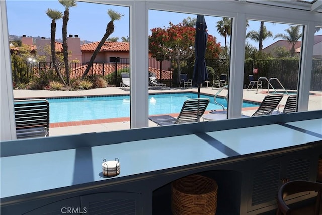 community pool with fence and a patio area