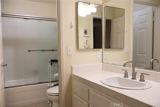 full bathroom featuring toilet, vanity, and shower / bath combination with glass door