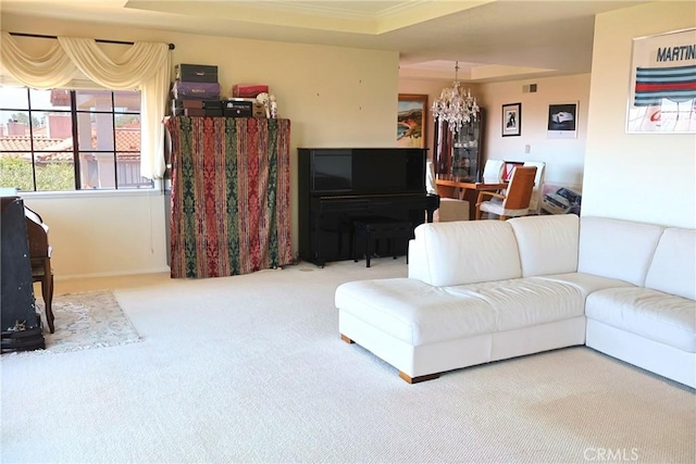 living area with a chandelier, carpet floors, ornamental molding, and baseboards