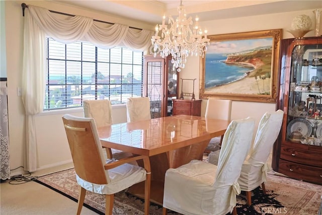 dining area featuring a chandelier, carpet, and baseboards