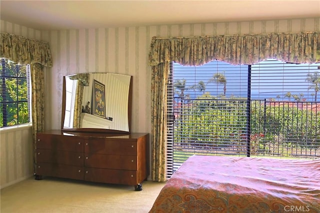carpeted bedroom featuring multiple windows and wallpapered walls