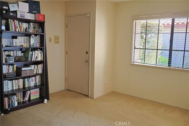 unfurnished room featuring carpet and baseboards