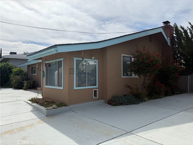 35014 Shasta St, Yucaipa, CA 92399 - view of property exterior with stucco siding, a patio, and a chimney