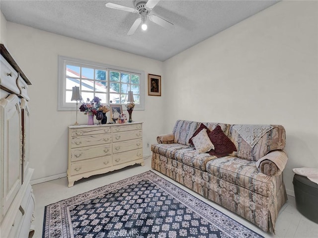 living area with a textured ceiling and ceiling fan