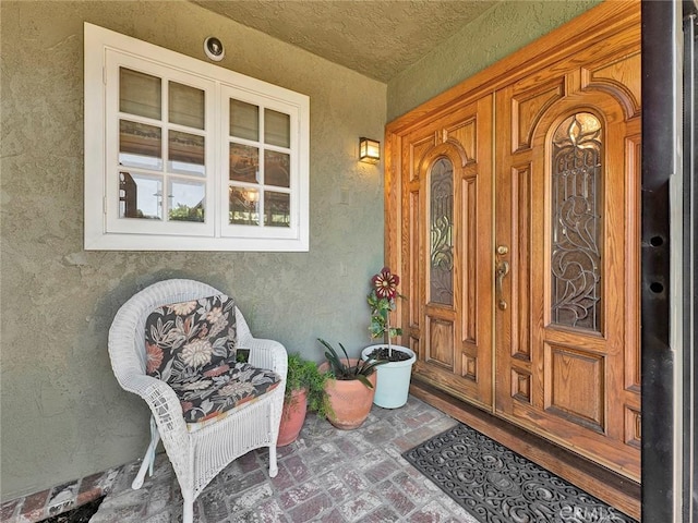 entrance to property with stucco siding and a porch