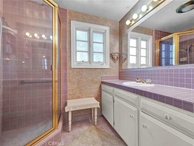 full bathroom with tile patterned flooring, a stall shower, and vanity