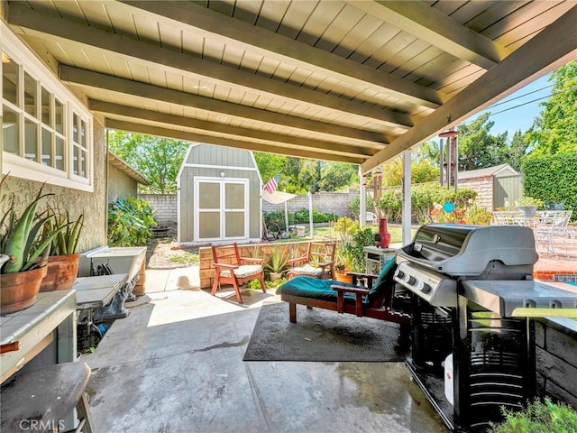 view of patio with a shed, a fenced backyard, an outdoor structure, and area for grilling