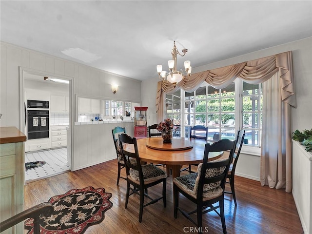 dining space with wood finished floors and a chandelier