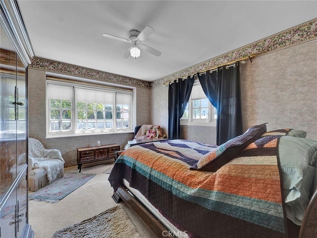carpeted bedroom with wallpapered walls and ceiling fan
