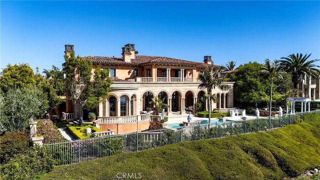 12 Skyridge, Newport Coast, CA 92657 - back of property featuring a balcony, a chimney, fence, and a patio