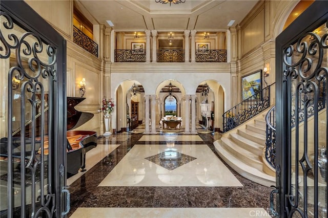 12 Skyridge, Newport Coast, CA 92657 - entrance foyer with arched walkways, marble tiled floors, stairs, ornate columns, and a towering ceiling