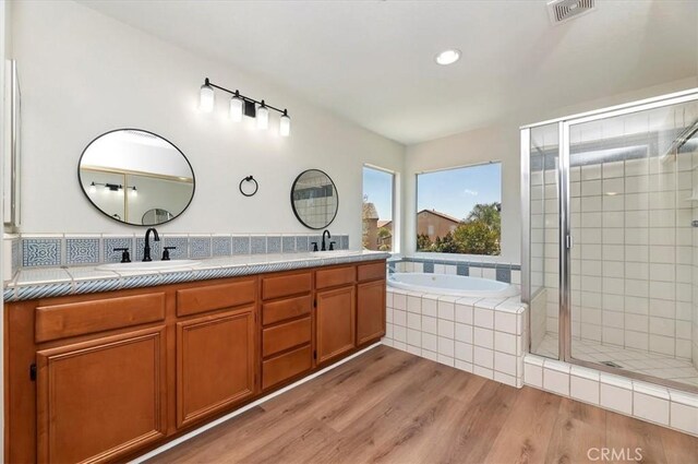 8167 Faircrest Rd, Riverside, CA 92508 - full bathroom with wood finished floors, a stall shower, a garden tub, double vanity, and recessed lighting