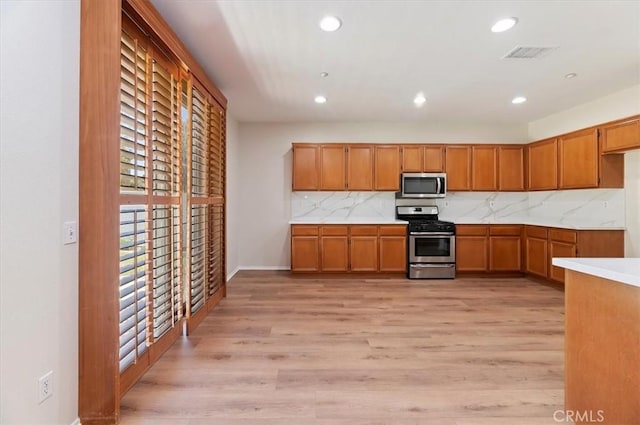 8167 Faircrest Rd, Riverside, CA 92508 - kitchen featuring stainless steel appliances, light countertops, light wood-style flooring, brown cabinets, and recessed lighting