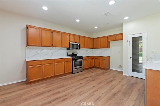 8167 Faircrest Rd, Riverside, CA 92508 - kitchen with stainless steel appliances, brown cabinets, light wood-style floors, backsplash, and recessed lighting