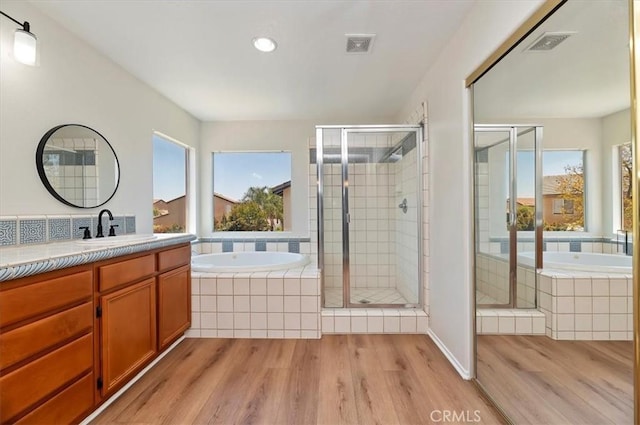 8167 Faircrest Rd, Riverside, CA 92508 - bathroom featuring wood finished floors, a stall shower, vanity, a garden tub, and recessed lighting
