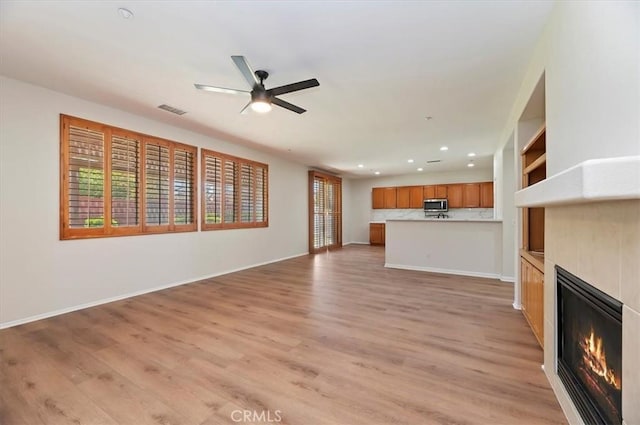 8167 Faircrest Rd, Riverside, CA 92508 - unfurnished living room with a glass covered fireplace, recessed lighting, a ceiling fan, light wood-style flooring, and baseboards