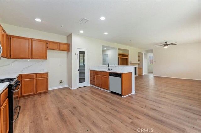 8167 Faircrest Rd, Riverside, CA 92508 - kitchen featuring black gas range, stainless steel dishwasher, brown cabinets, a peninsula, and light countertops