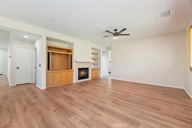 8167 Faircrest Rd, Riverside, CA 92508 - unfurnished living room featuring ceiling fan, baseboards, light wood-type flooring, a glass covered fireplace, and built in features