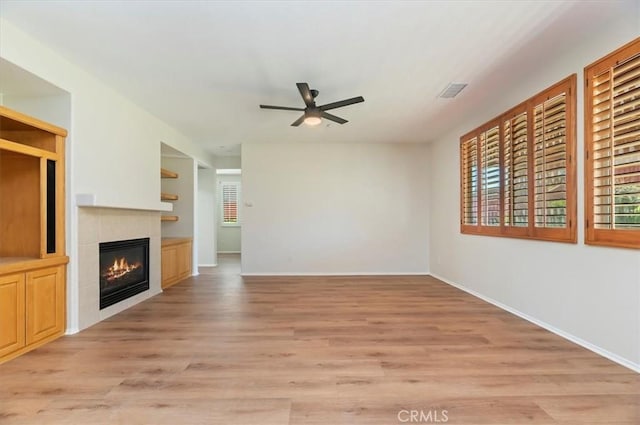 8167 Faircrest Rd, Riverside, CA 92508 - unfurnished living room with ceiling fan, a tiled fireplace, light wood-style floors, and baseboards