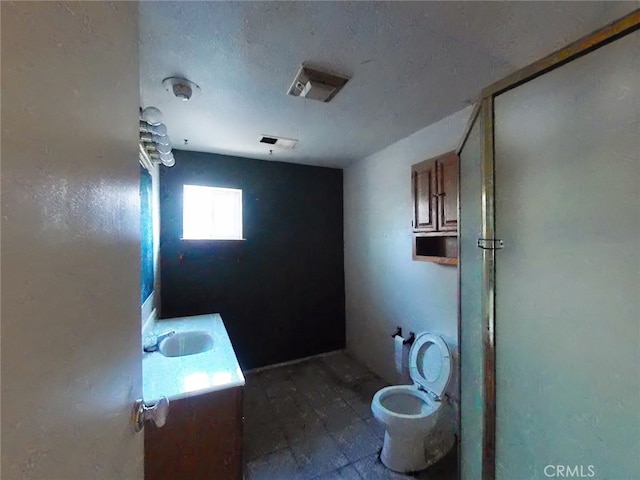 410 5th St, Willows, CA 95988 - bathroom featuring a shower with shower door, vanity, toilet, and a textured ceiling