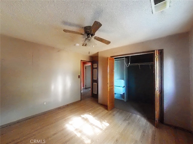 410 5th St, Willows, CA 95988 - unfurnished bedroom with light wood-style floors, a closet, a textured ceiling, ceiling fan, and baseboards