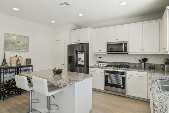 30527 Expedition Dr, Winchester, CA 92596 - kitchen featuring stainless steel appliances, white cabinetry, light wood-style floors, light stone countertops, and recessed lighting