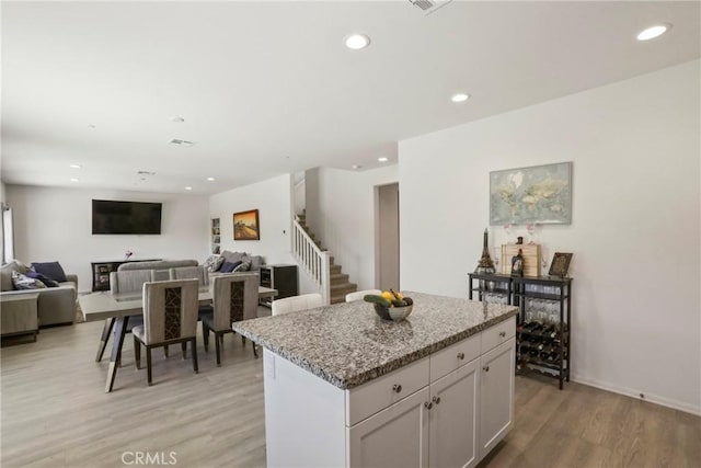 30527 Expedition Dr, Winchester, CA 92596 - kitchen featuring a center island, light wood finished floors, white cabinets, recessed lighting, and light stone counters