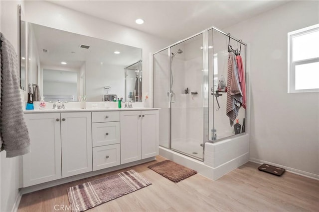 30527 Expedition Dr, Winchester, CA 92596 - bathroom featuring wood finished floors, double vanity, a stall shower, and recessed lighting