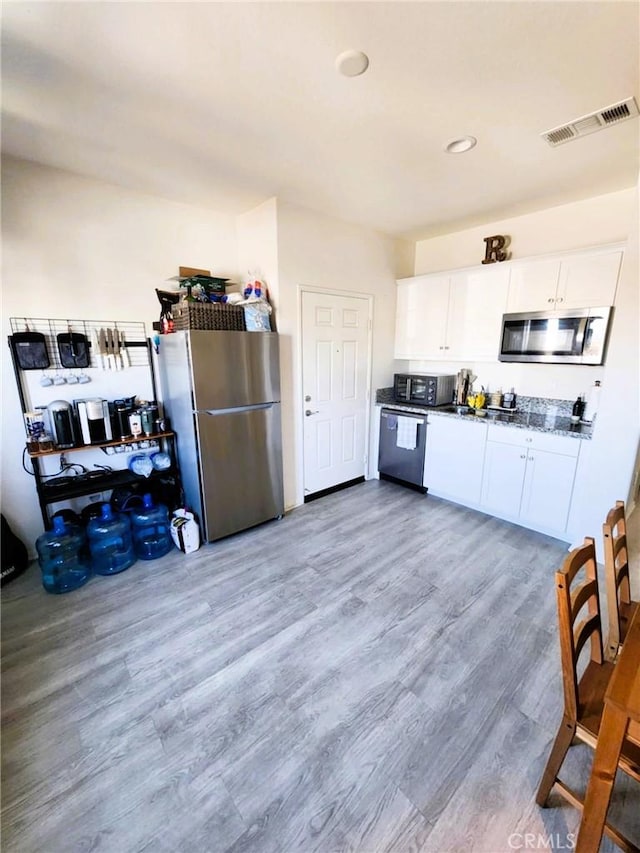 30527 Expedition Dr, Winchester, CA 92596 - kitchen featuring stainless steel appliances, wood finished floors, white cabinetry, and recessed lighting