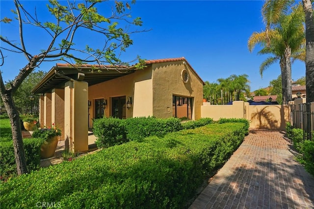 4437 Owens St Unit 104, Corona, CA 92883 - view of side of home featuring stucco siding, a gate, and fence